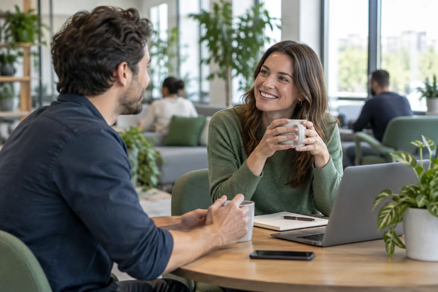 Two colleagues talking in a bright office breakout area